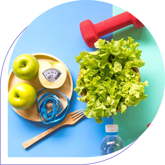 A blue table with green apples, lettuce and a red dumbbell.