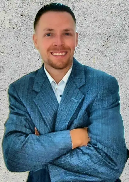 A man in a blue suit with his arms crossed.