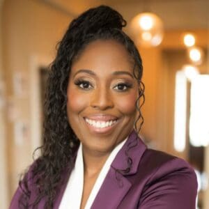 Smiling woman in a purple suit.