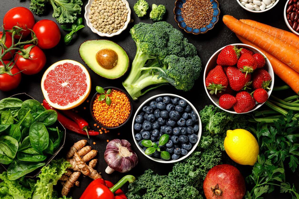 Assorted fruits and vegetables on a dark background.