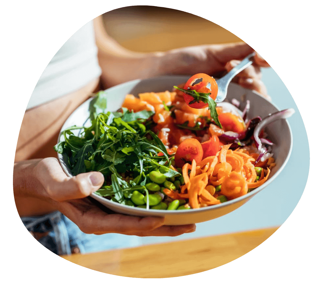 Person holding colorful salad with vegetables.